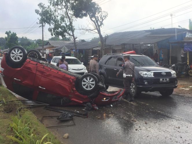 
					Polisi Sedang Mengevakuasi Mobil Toyota Yaris Yang Terbalik Di Kilometer 16