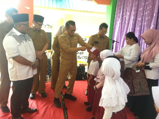 
					Pj Walikota Tanjungpinang Andri Rizal saat memakaikan topi sekolah kepada anak SD, Selasa  (24/12/2024)-Hendrik