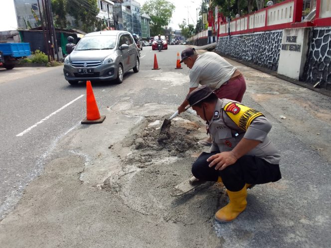
					Bhabinkamtibmas saat melakukan semenisasi jalan yang rusak (Humas Polresta Tanjungpinang)