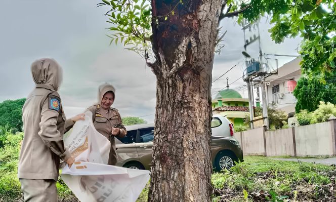 Keterangan Foto: Satuan Polisi Pamong Praja (Satpol PP) Kota Tanjungpinang saat menertibkan lembar pamflet yang dipasang secara sembarangan di sejumlah lokasi, seperti pada pohon, tiang listrik, dan rambu lalu lintas di kawasan Jalan Ir. Sutami, Ir. Juanda, dan DI. Panjaitan, (Diskominfo Tanjungpinang).