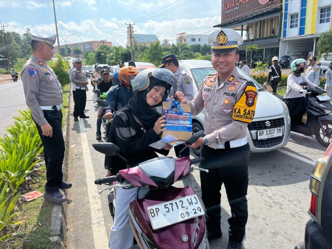 
					Kasat Lantas Polresta Tanjungpinang, AKP Arbi Guna Bimantara saat memberikan bingkisan kepada pengguna jalan. (Satlantas Tanjungpinang)