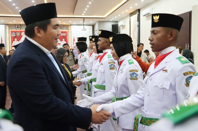 
					Bupatii Bintan, Roby Kurniawan saat berjabat tangan bersama peserta paskibraka seusai di Kukuhkan, di Di Ballroom Awandari Resort, Jumat (15/8/2025). (Diskominfo Bintan)