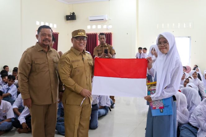 
					Keterangan Foto: Wagub Nyanyang didampingi Kepala Kesbangpol Kepri M Ikhsan saat menyerahkan bendera merah putih kepada siswa SMKN 1 Bintan Timur, (Diskominfo Kepri).