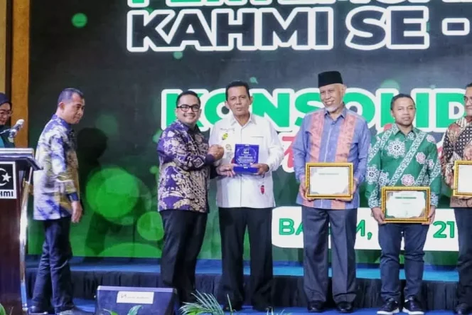 
					Gubenur Kepri, Ansar Ahmad saat menerima cendra mata pada Pertemuan Regional Korps Alumni Himpunan Mahasiswa Islam (KAHMI) se-Sumatera, di Swiss-Belhotel Harbourbay, Batam, Sabtu (20/9/2025). (Diskominfo Kepri)