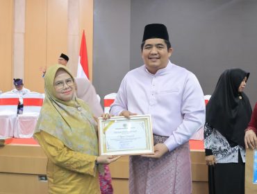 Bupati Roby saat menyerahkan penghargaan pada salah satu guru di Bintan.(Foto Humpro Pemkab Bintan)