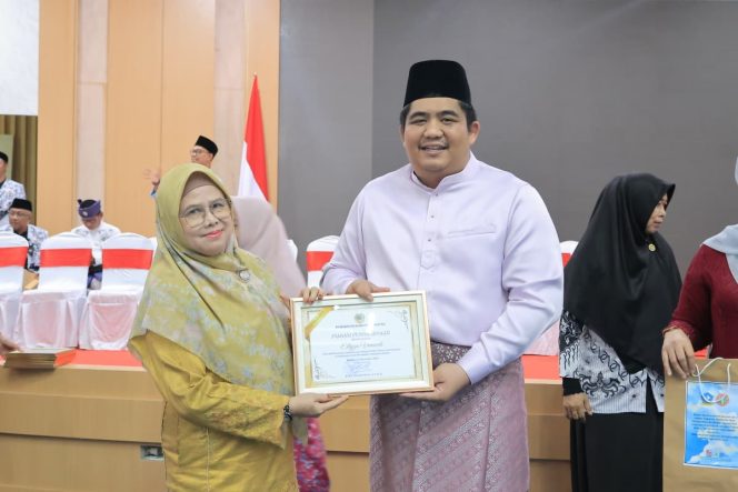 
					Bupati Roby saat menyerahkan penghargaan pada salah satu guru di Bintan.(Foto Humpro Pemkab Bintan)