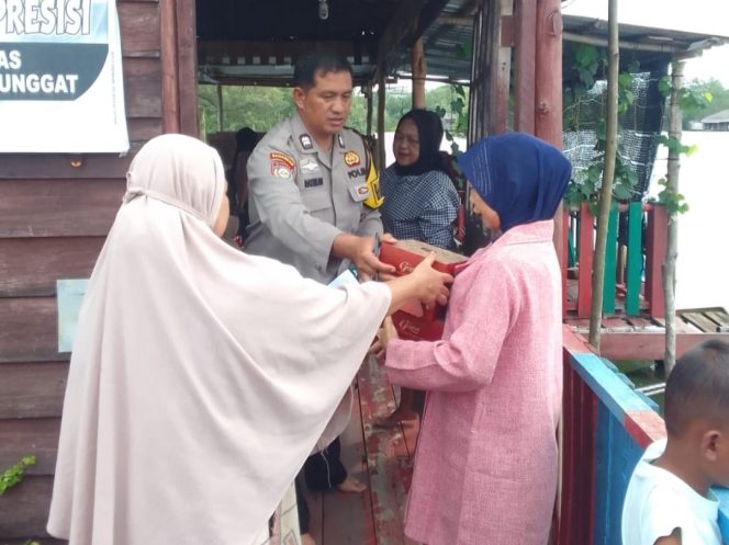 
					Bhabinkamtibmas Kelurahan Tanjung Unggat, Aiptu Razmud membagikan paket makanan gratis kepada masyarakat setempat, Senin (08/12/2025). (Humas Polresta Tanjungpinang)