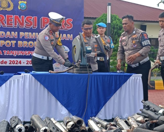
					Tengah, Kapolresta Tanjungpinang, Kambes Pol Hamam Wahyudi didampingi Kasat Lantas Polresta Tanjungpinang AKP Arbi Guna Bimantara saat memotong knalpot, Senin (29/12)