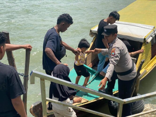 
					Anggota Polsek Tanjungpinang Kota saat membantu wisatawan yang saat menaiki Pompong ke Pulau Penyengat, Senin (23/03).F-Kepri.info