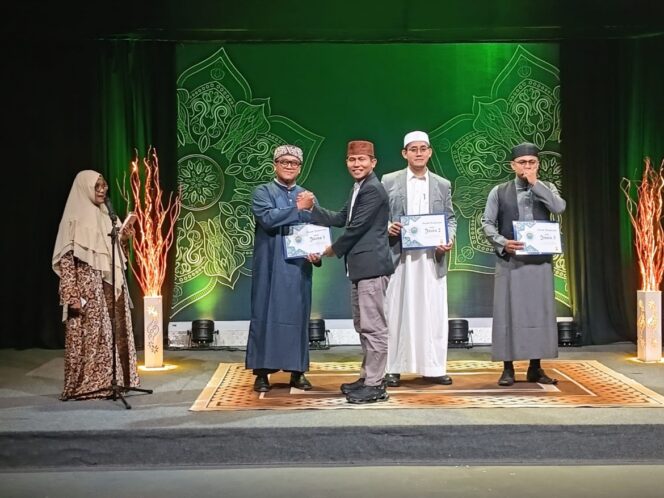 
					Amrie Poerbha Yogya Sayektie (dua dari kiri) terima penghargaan juara satu dari ketau FKM Kota Tanjungpinang