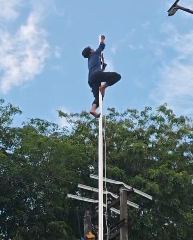 
					Tan Arifin Rambe, Petugas Dinas Pemadam Kebakaran dan Penyelamatan Kota Tanjungpinang saat memanjat tiang bendera setinggi lebih kurang 15 meter, Kamis (23/04) sore. F-kepriinfo 