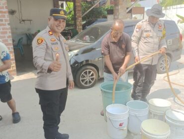 Kapolsek Tanjungpinang Kota IPTU Freddy Simanjuntak, S.H., bersama personel bersama Personilnya membagikan air bersih kepada Warga, Selasa (18/08)