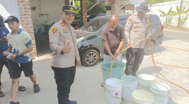 Kapolsek Tanjungpinang Kota IPTU Freddy Simanjuntak, S.H., bersama personel bersama Personilnya membagikan air bersih kepada Warga, Selasa (18/08)