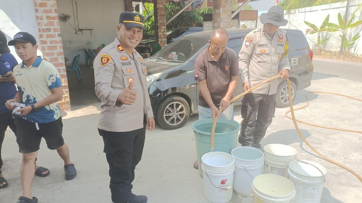 Kapolsek Tanjungpinang Kota IPTU Freddy Simanjuntak, S.H., bersama personel bersama Personilnya membagikan air bersih kepada Warga, Selasa (18/08)